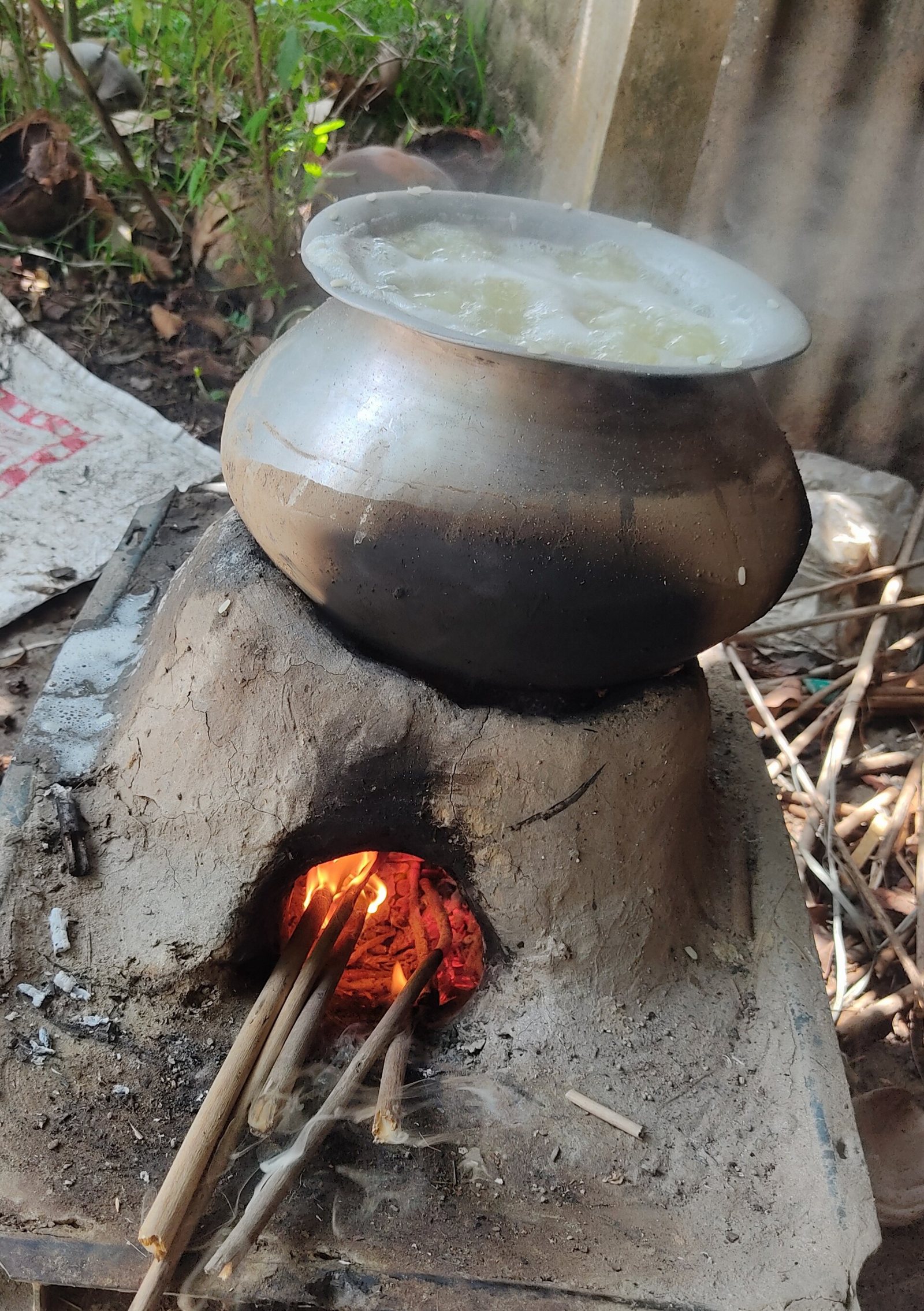 A clay pot cooking over a wood fire